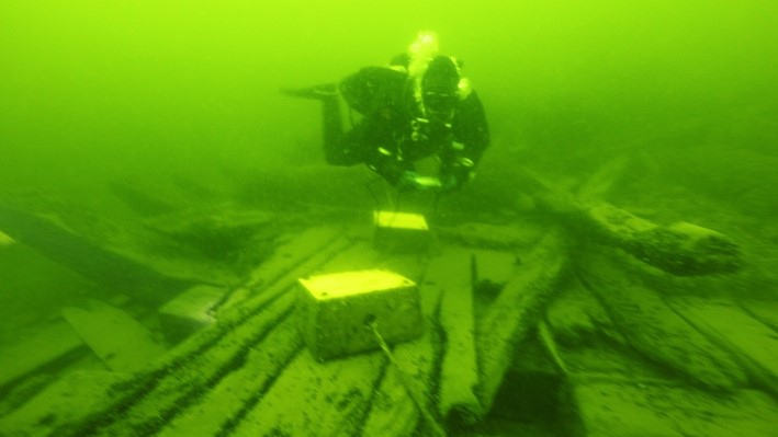A diver is following the guided route of the wreck park.