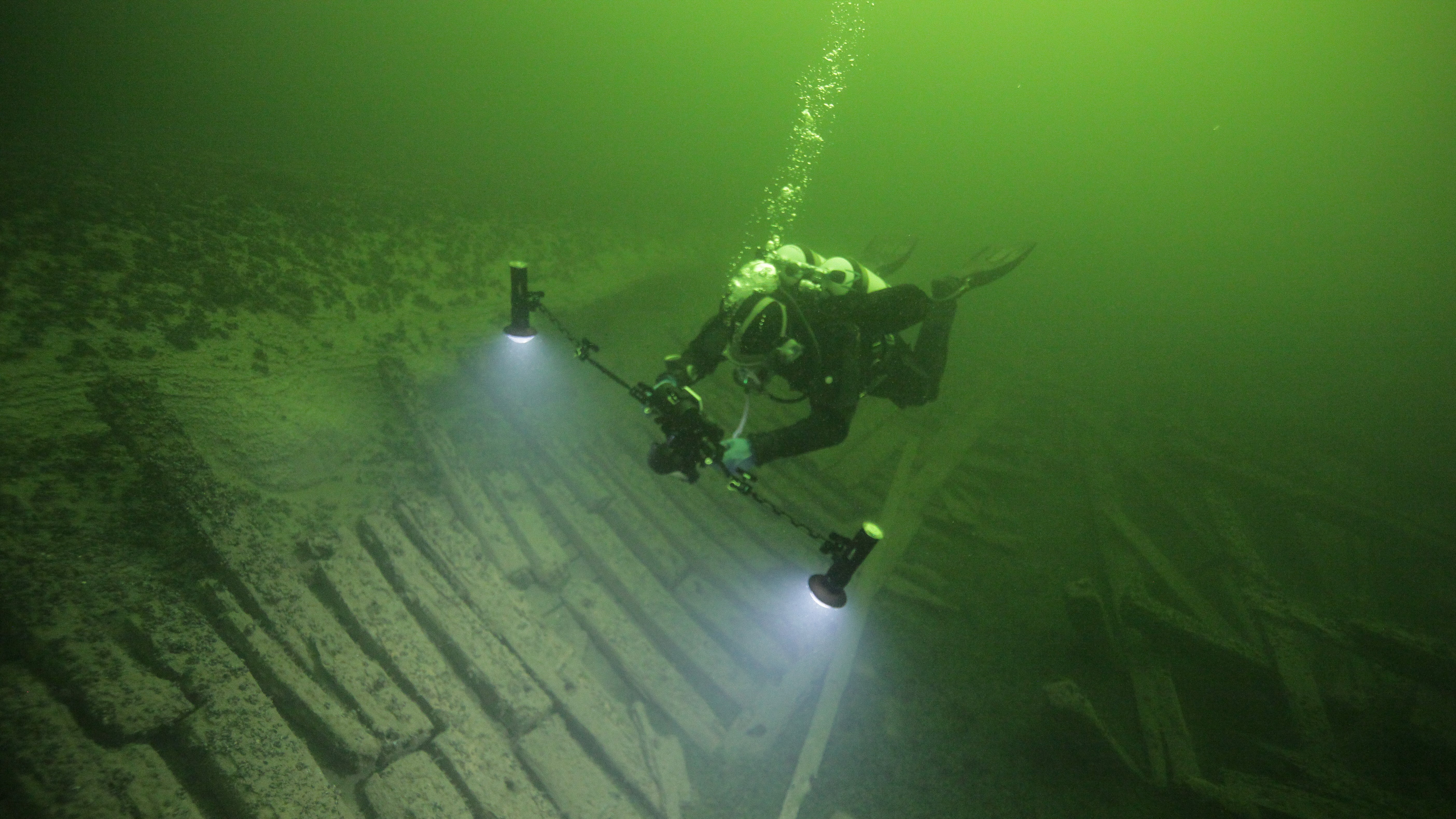 Diver photographing the hull arches lying against the seabed.