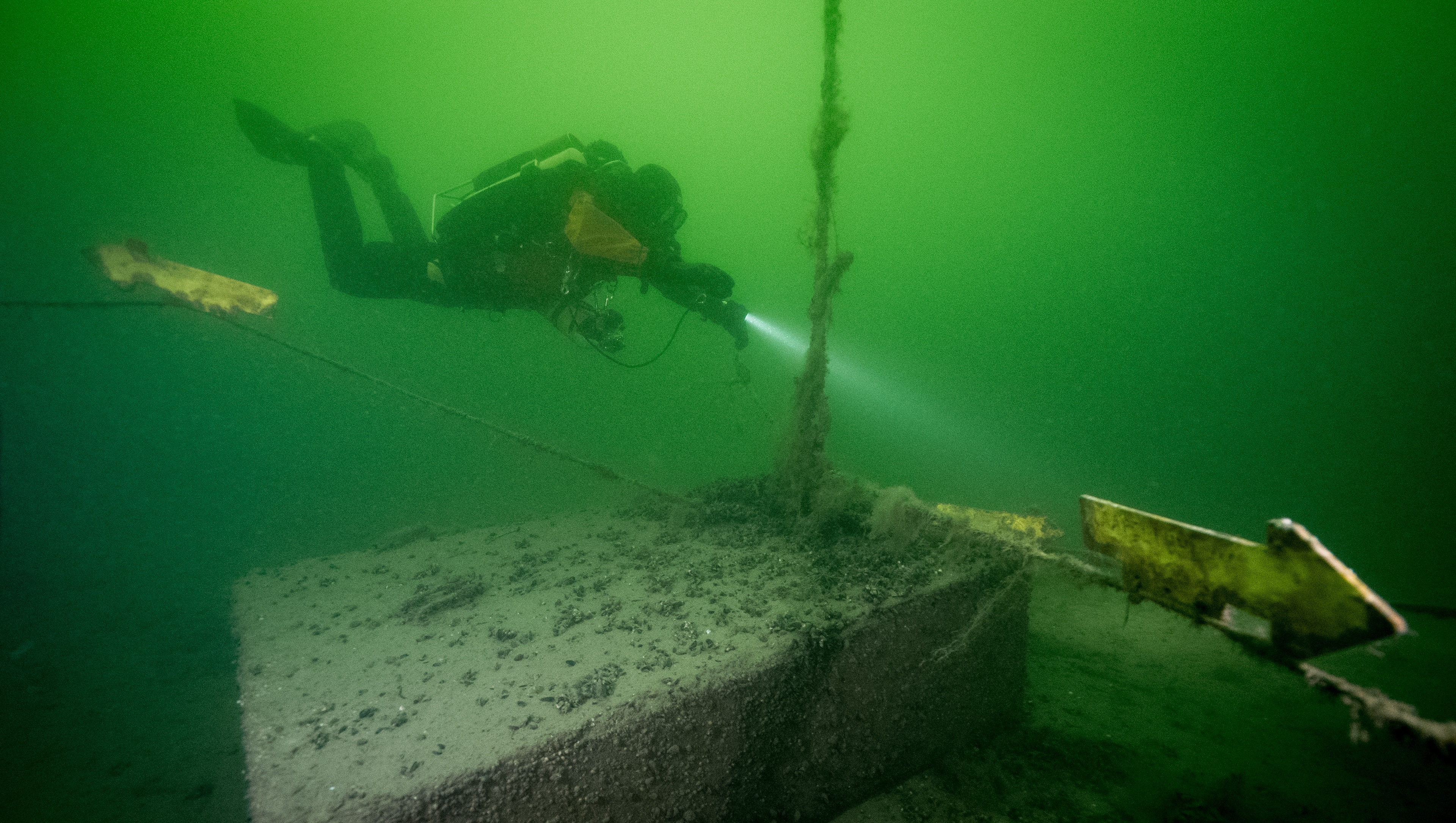 Diver following the path indicated by an arrow attached to the wreck park's guide rope.